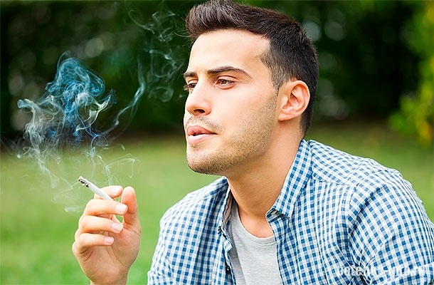 Молодой мужчина курит